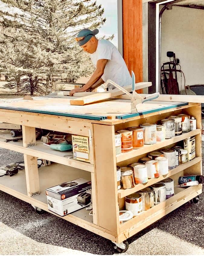DIY Mobile Workbench Man working at workbench with paint cans and tools outside on workbench.