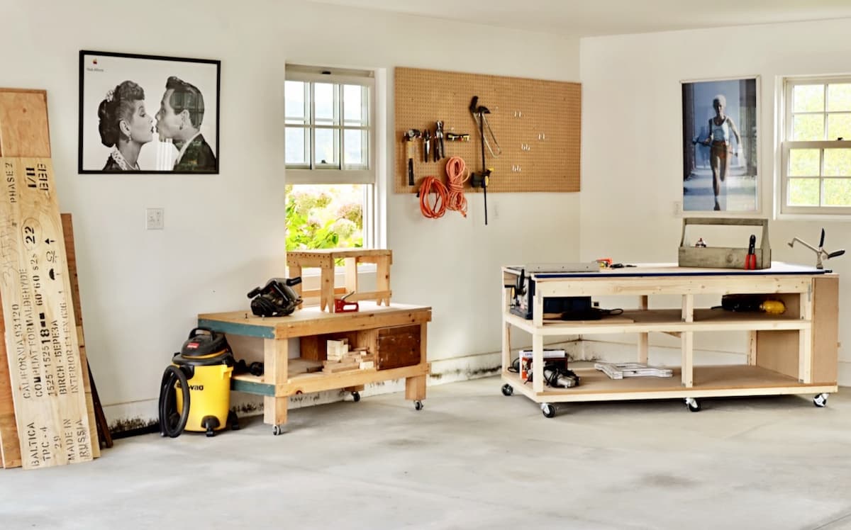 DIY Mobile Workbench and Home Workshop Reveal Garage with workshop area in the corner with workbench, pegboard with tools and saw.