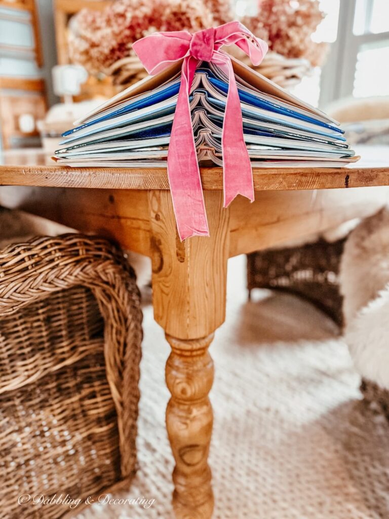 Book Christmas tree with pink bow resting on table as a holiday accent.