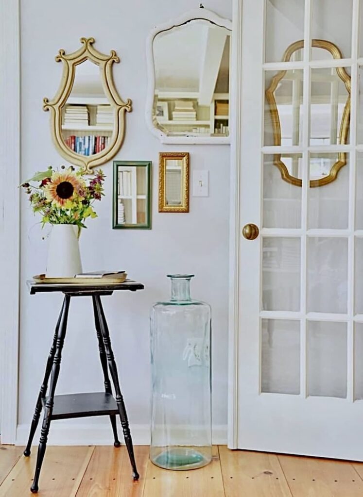 Sunroom makeover ideas with a gallery wall of mirrors and open french door to the room.
