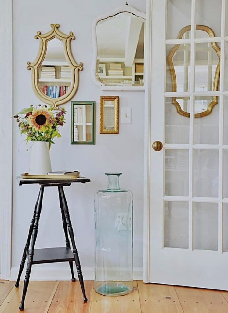 Wall with layered vintage mirrors in vintage room design.