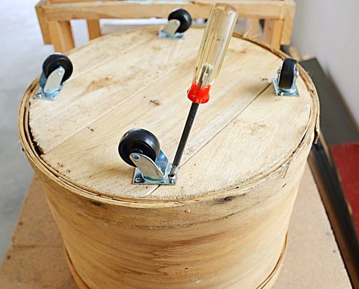 Cheese crate upside down with casters and screw driver