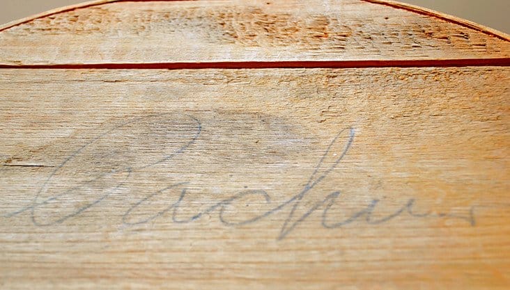 Pacha writing on top of old cheese crate