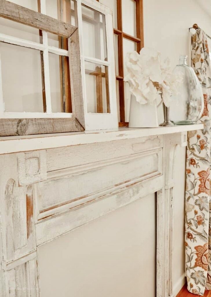 Vintage white faux mantel on dining room wall with layered old windows.