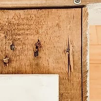 Wooden back of faux vintage mantel with attached wall screw.