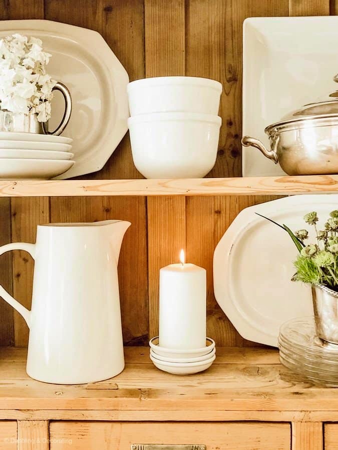 White farmhouse decor accessories on pine shelving.