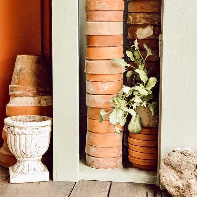 stacked terracotta pots in garden cupboard