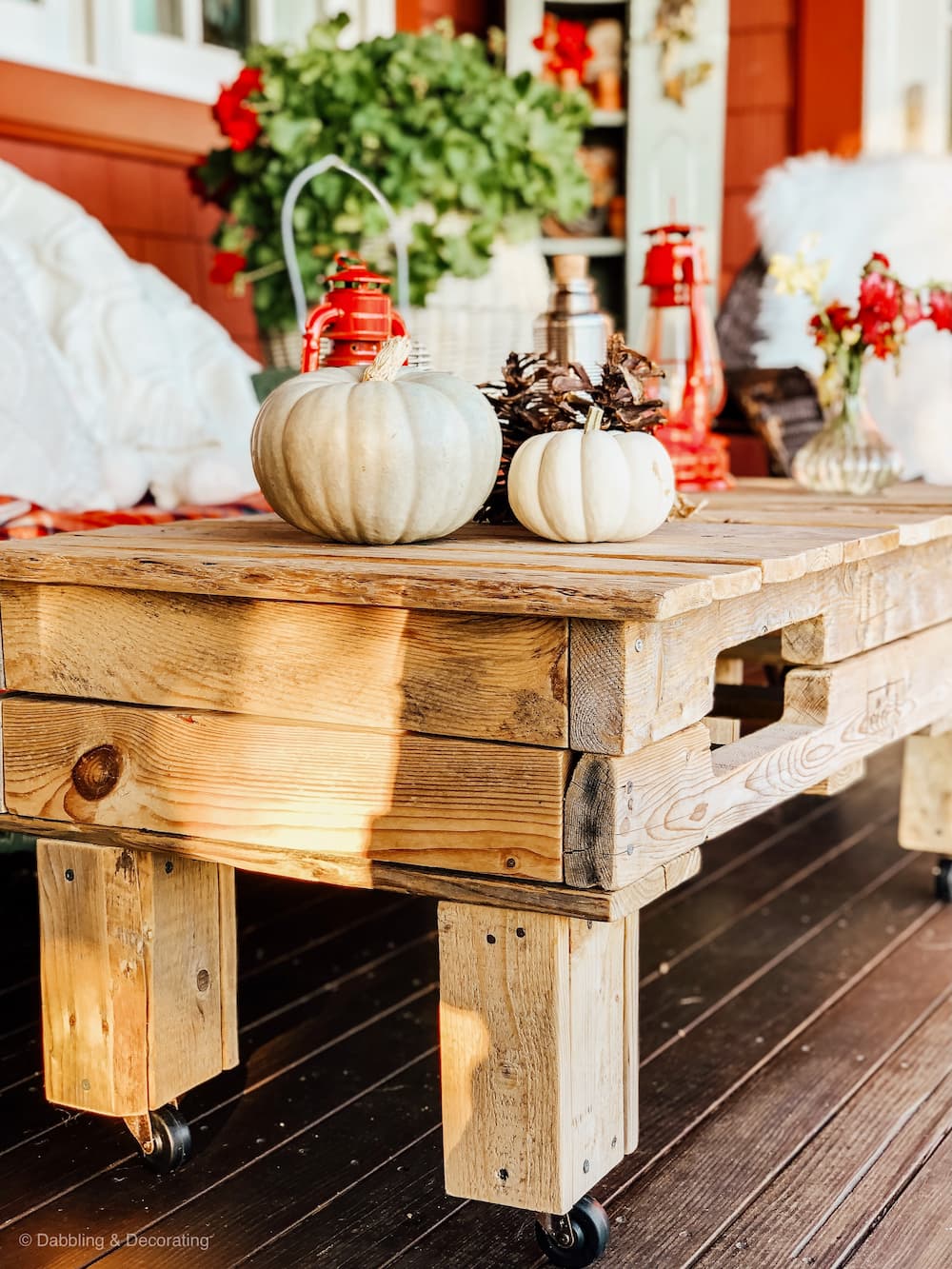DIY pallet coffee table decorated for fall on porch.