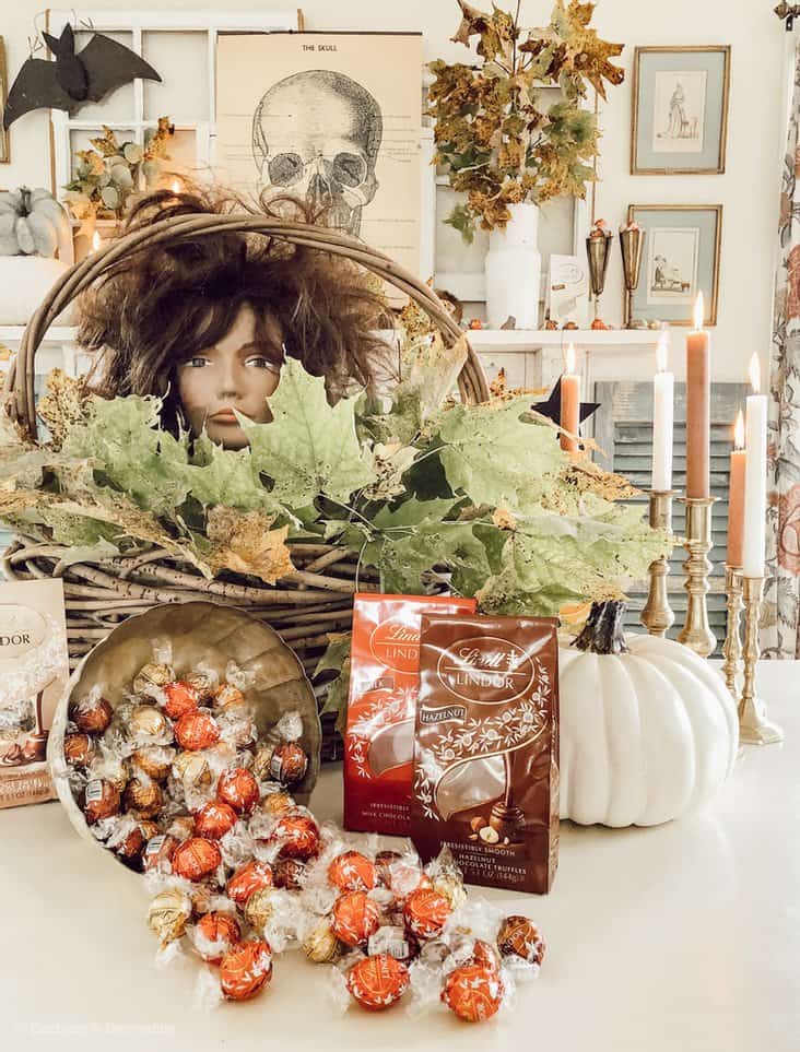 Halloween Vintage Mantel ideas with Lindt Lindor Chocolates.  A mannequin head in a basket of leaves displayed.