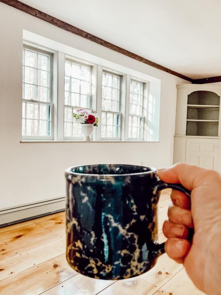 Old Family Home Restoration Blue Bennington Pottery Mug in hand cheering to newly refinished inside Raeside-Dame Vintage Home Restoration.