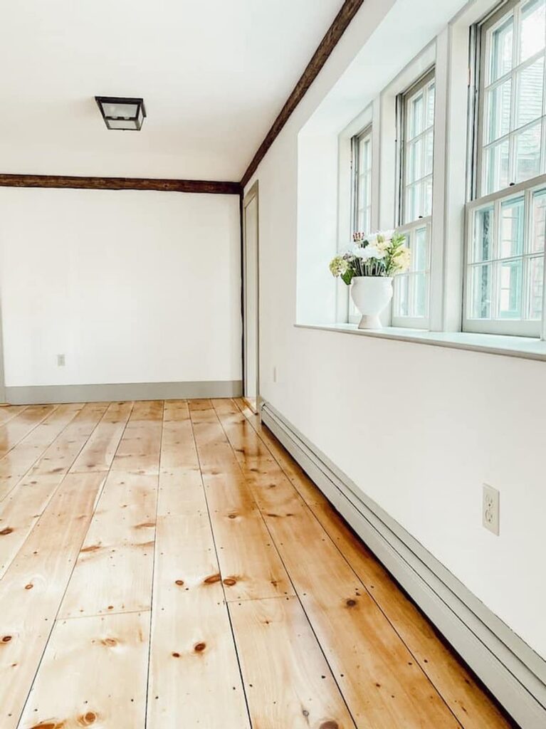 Vintage home renovation dining room with newly refinished pine flooring, Nantucket Gray paint trim and Simply White walls.