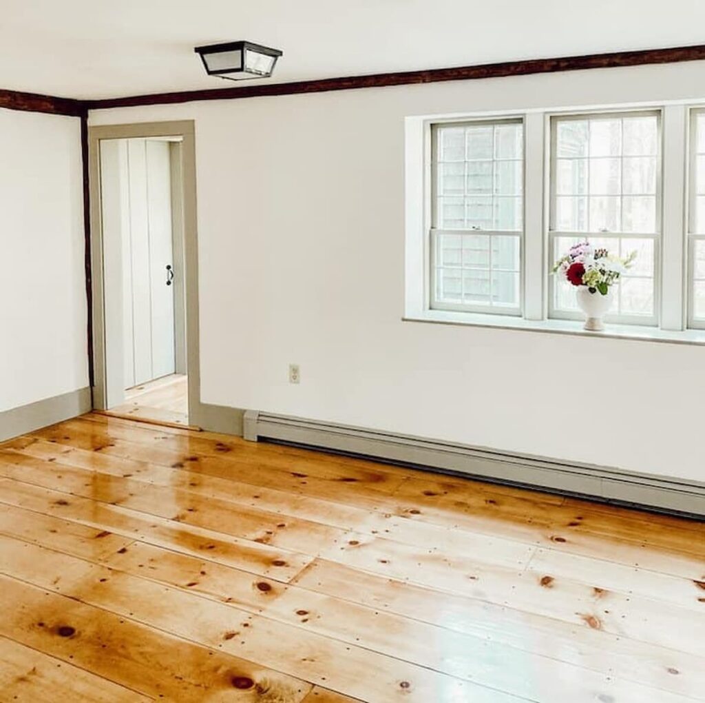 Vintage home renovation dining room with newly refinished pine flooring, Nantucket Gray paint trim and Simply White walls.