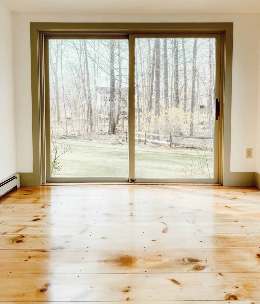 Vintage home restoration with newly refinished pine flooring, simply white walls and Nantucket trim.