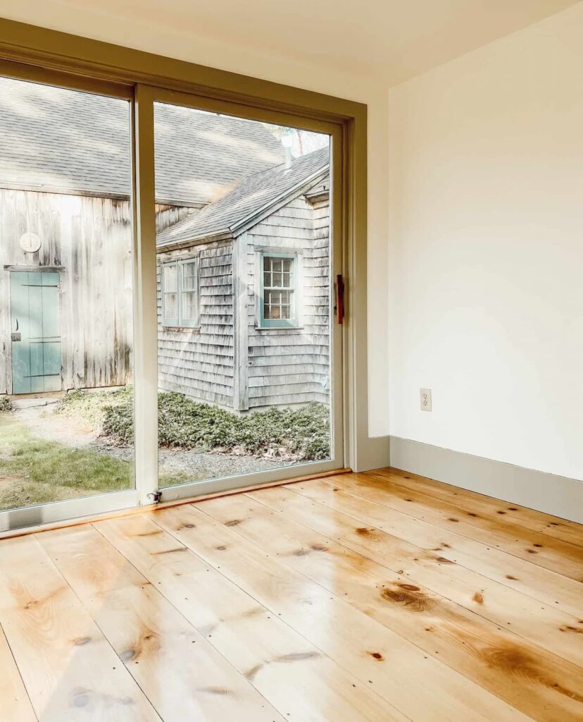Vintage home restoration with newly refinished pine flooring, simply white walls and Nantucket trim.