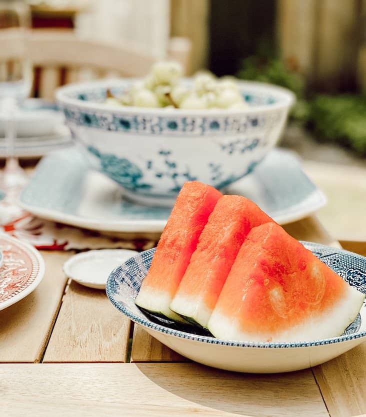 Watermelon in vintage bowl on outdoor table.