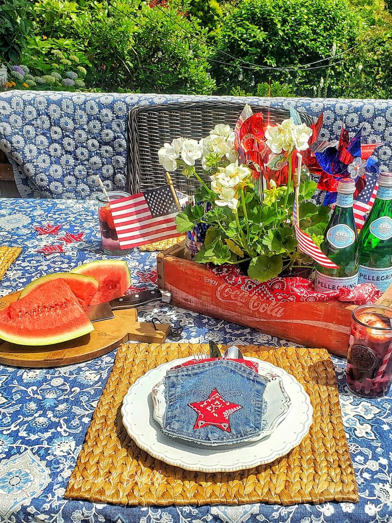 Patriotic alfresco table setting with jean pockets and bandanas and vintage crate centerpiece.