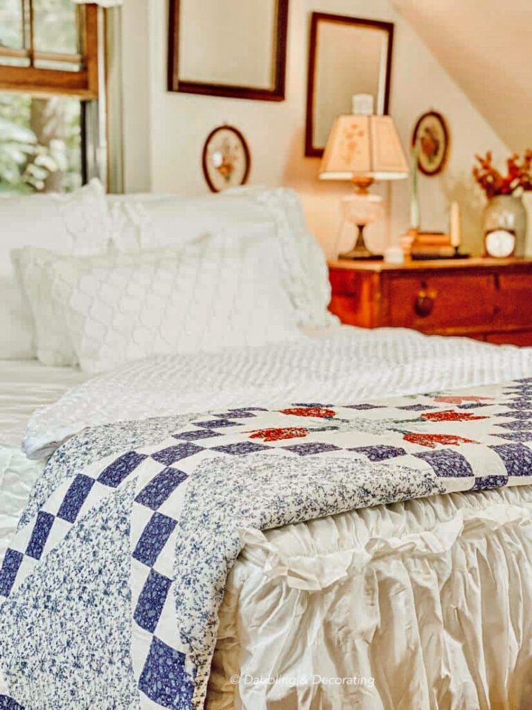 Quaint small attic bedroom with white Beddy's Zipper Bedding and vintage quilt at foot of bed.