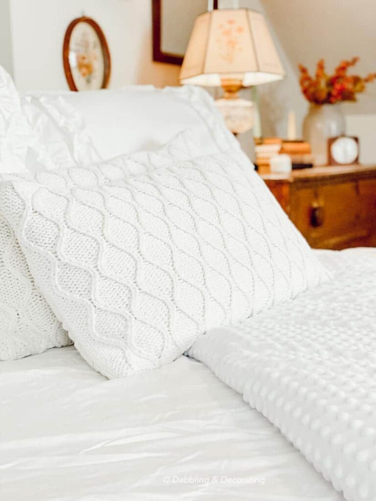White bedding in small quaint bedroom.