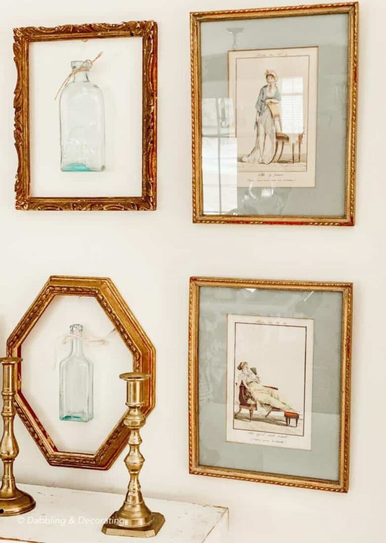 Layering vintage gold frames on wall decor with bottles and brass candlesticks.