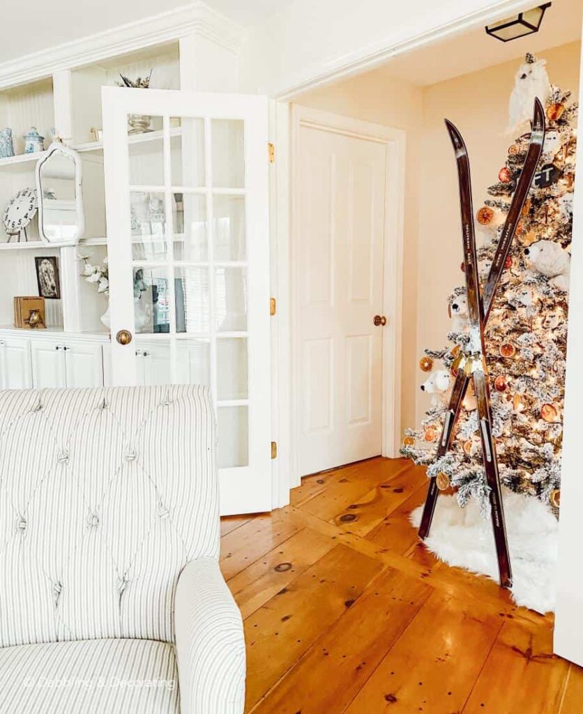 Christmas tree in entryway decorated with Polar bears, owls, and orange slices and vintage skis.