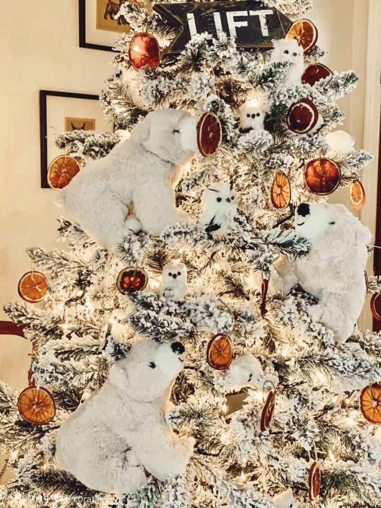 King of Christmas tree flocked with polar bear Christmas decor, owls, orange slices and vintage ski lodge sign.