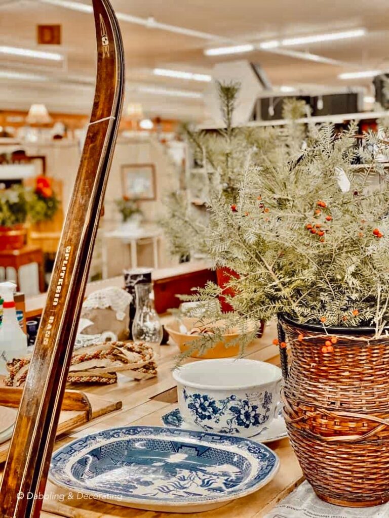 Antique skis and thrifted finds at the counter of an antique shop for holiday decor.