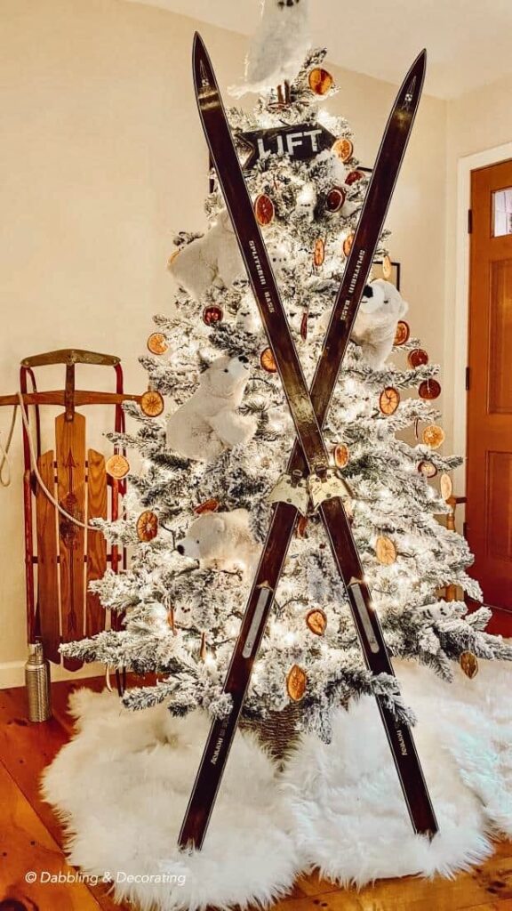 King of Christmas tree with polar bear Christmas decor and crossed vintage cross country skis on sheepskin rugs.