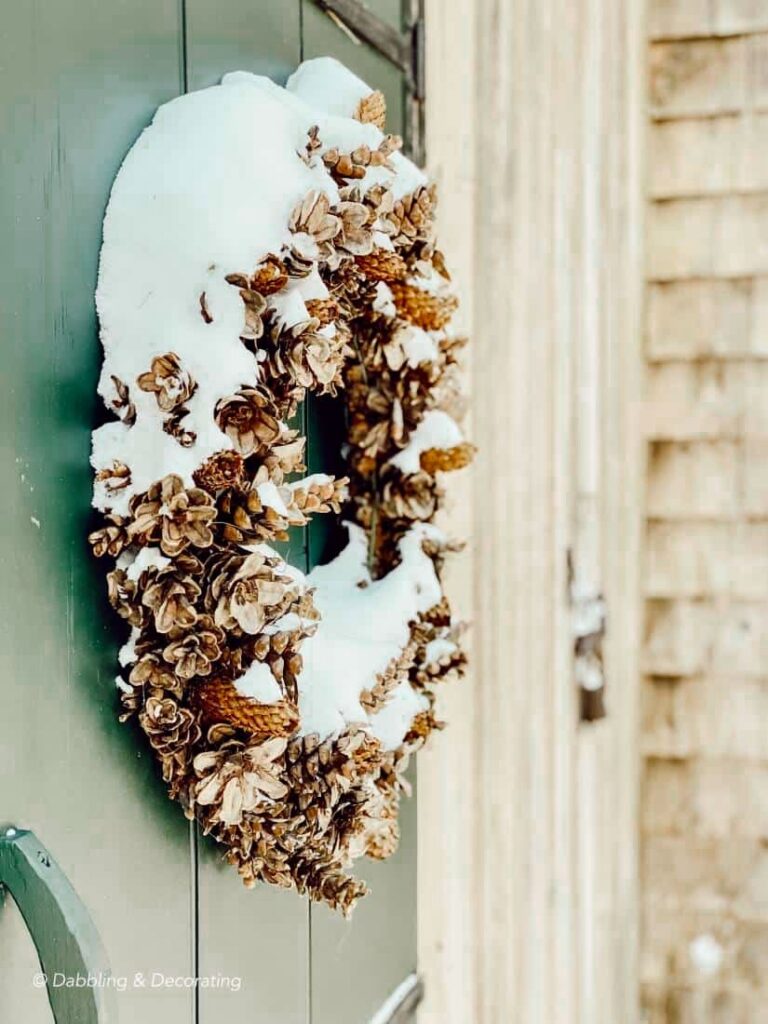 Pinecone wreath and snowy green door