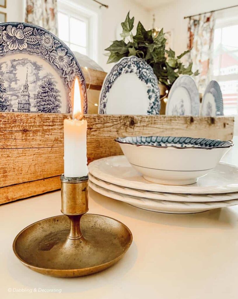 Wooden toolbox with plates centerpiece with candle on table.