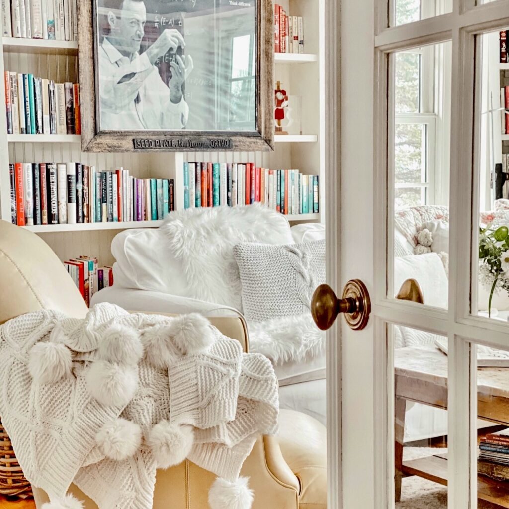 Small cozy home library with vintage bookshelf decor with framed antique picture and cozy furnishings.