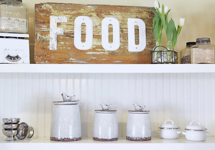 Vintage wooden FOOD sign on top kitchen shelf with other vintage decor.