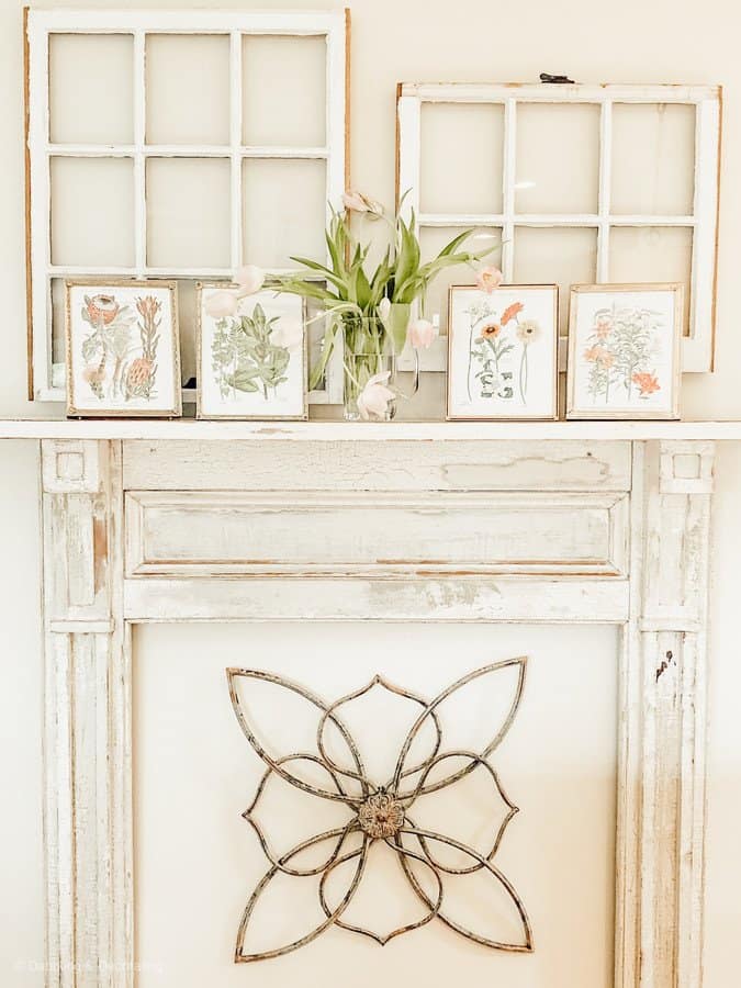 Vintage fireplace mantel with framed spring botanicals.