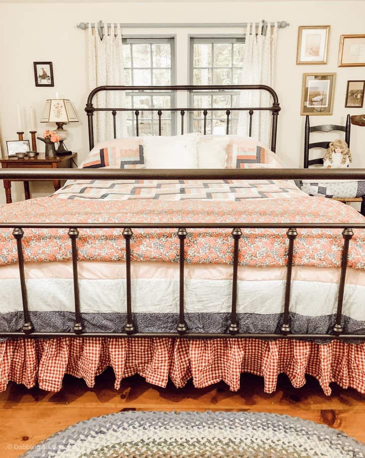 rod iron bed with vintage bedding.