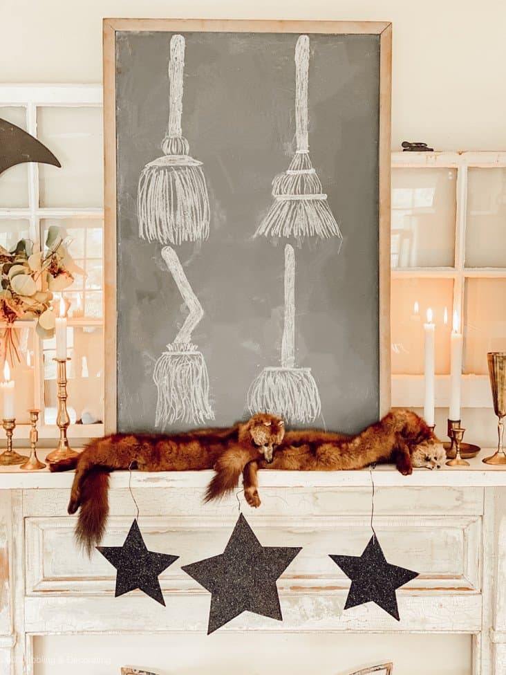 Halloween Mantel displayed with chalkboard with witch's broom drawings, vintageminks and candlesticks.  Halloween Decorations Vintage