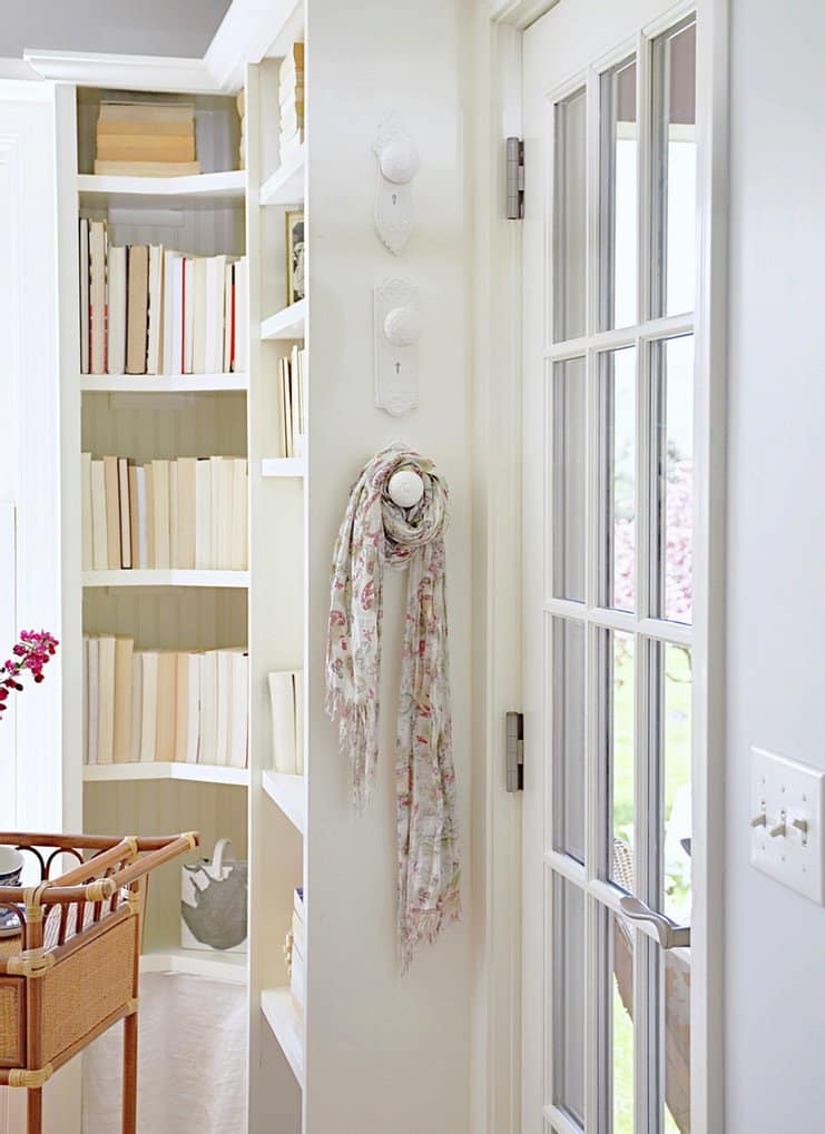 Porcelan white door knob wall hangers and bookshelves w/ books.