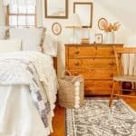 A bedroom with a bed and a chair in a room