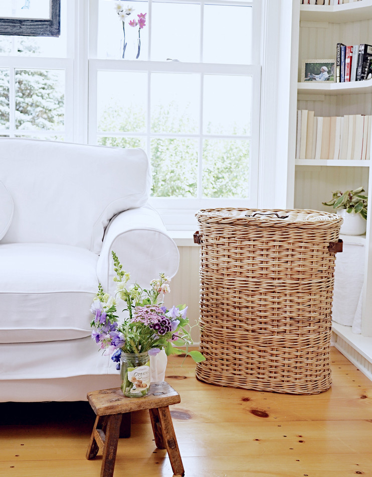 Sunroom makeover w/ builtins, basket white loveseat and market flowers with vintage flair.