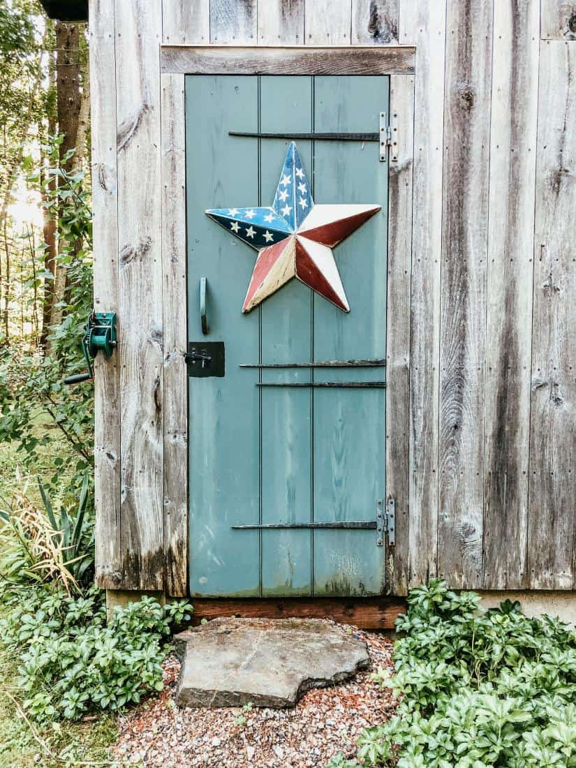 weathered cedar shake siding and door with patriotic star on home.