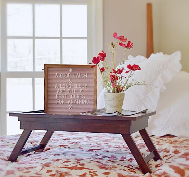 pink felt letter board, breakfast tray, flowers on a high vintage bed with white pillows in the guest bedroom. pink felt letter board, breakfast tray, flowers on a high vintage bed with white pillows in the guest bedroom.