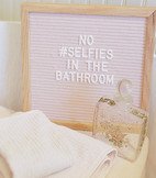 letter board with vintage perfume bottle and pink towels.