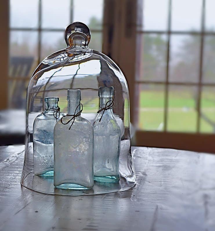 Cloche with blue vintage bottles.