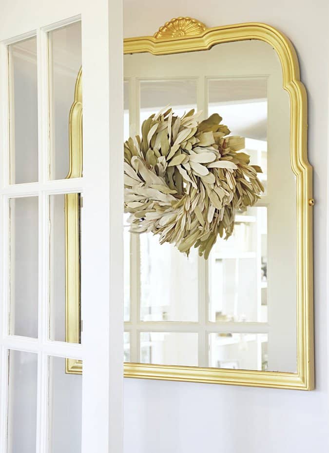 Vintage gold mirror with neutral wreath.