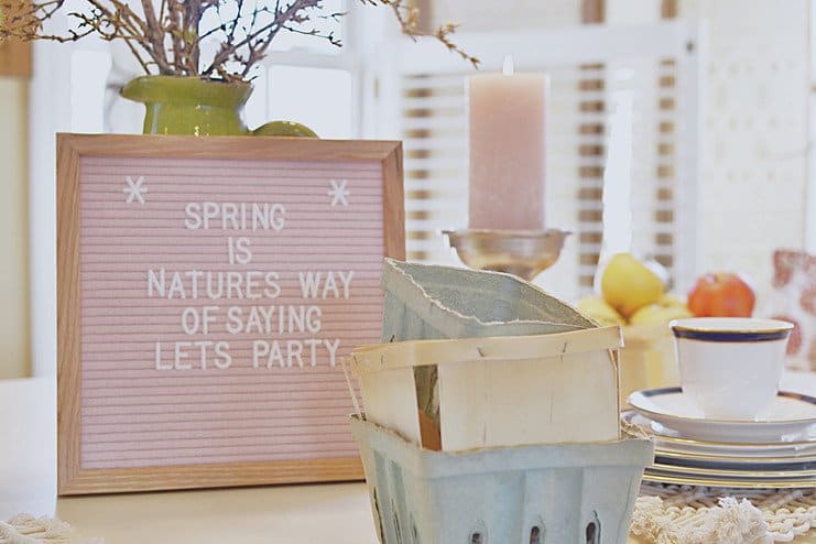 Pink felt letter board, berry boxes, china and green vase on white dining room table. Pink felt letter board, berry boxes, china and green vase on white dining room table.