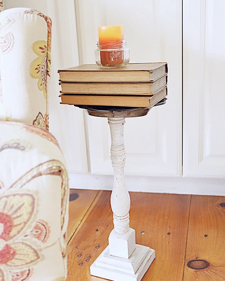 Vintage books with orange candle in jar for fall decor.