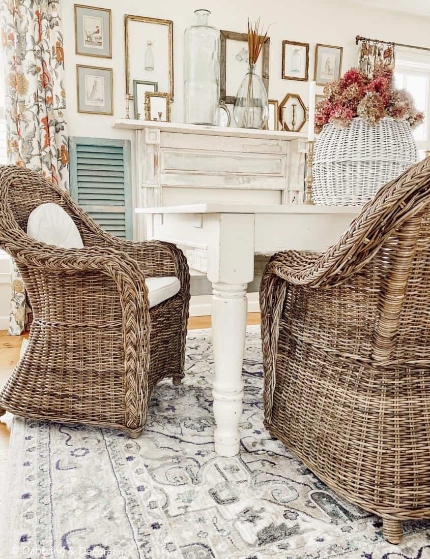 Dining Room table and chairs in front of vintage gold frames wall display and mantel.