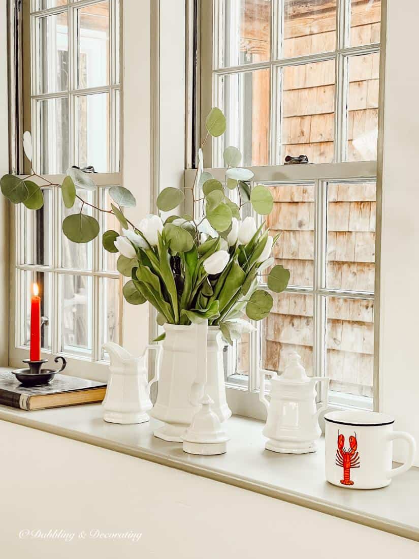 Tulip and greenery display and lobster mug on window sill