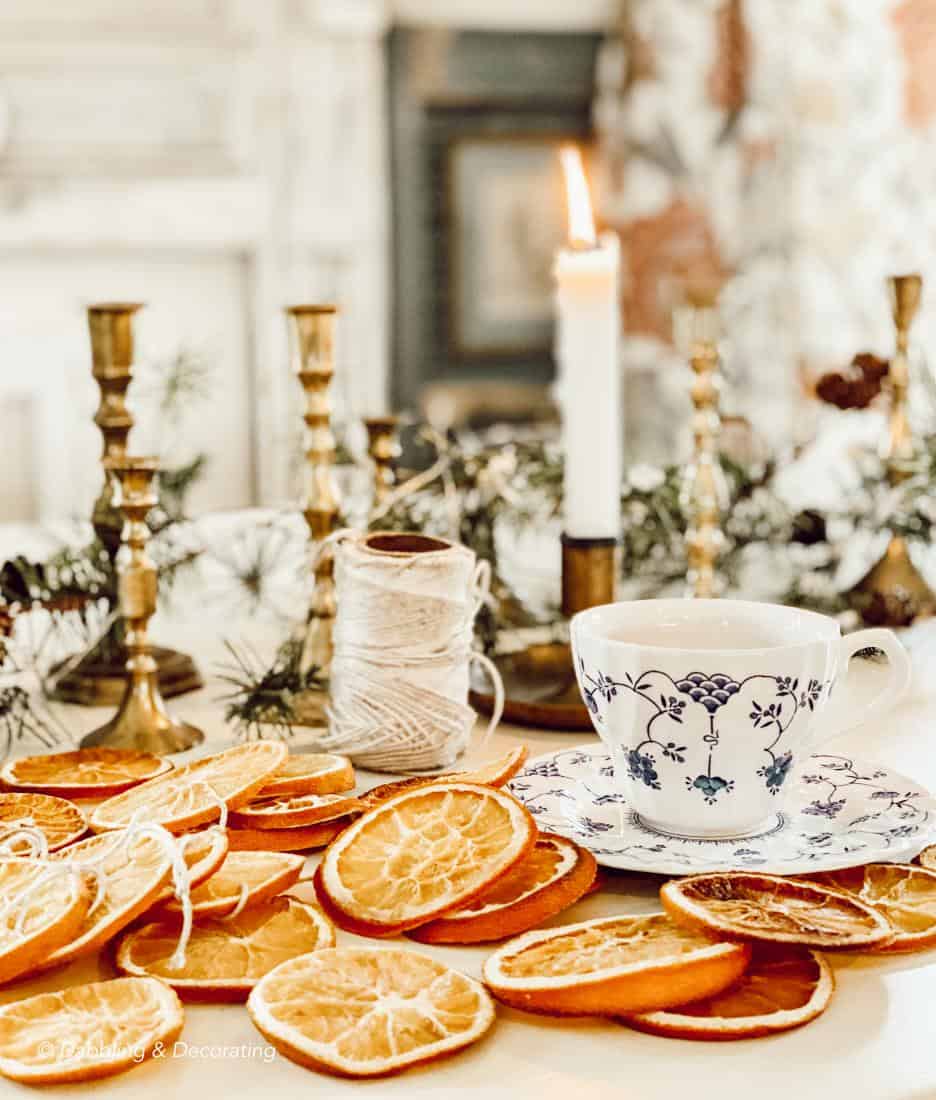 Dried oranges scattered on table with a vintage teacup for the holidays.