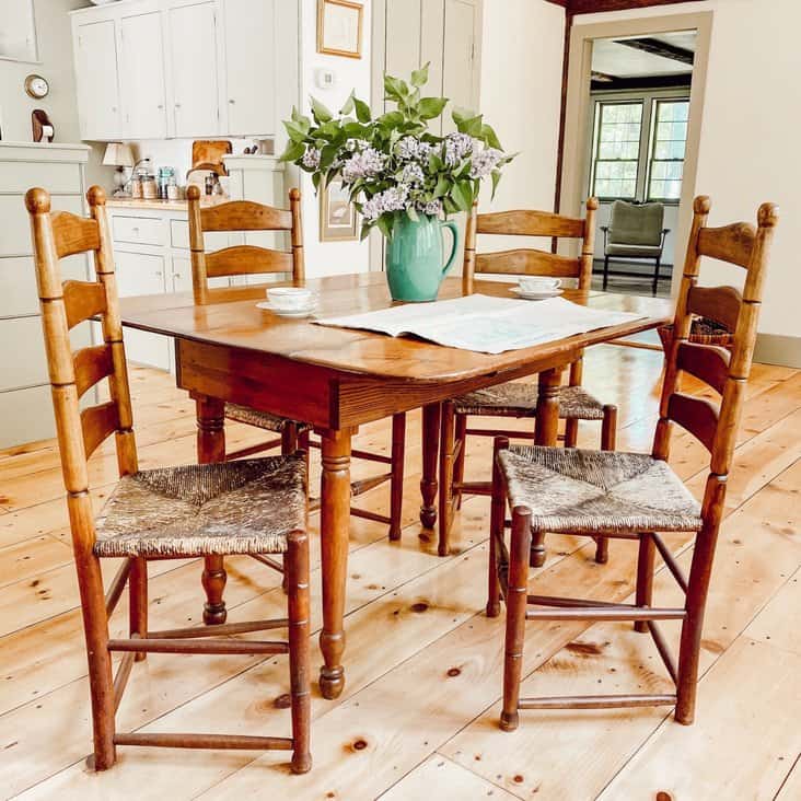 Dining room table with old colonial house plans on table with Lilac bouquet.