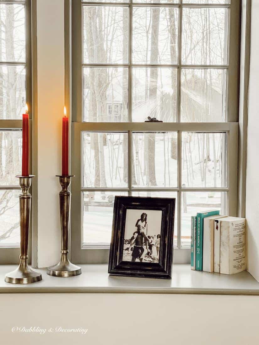 Framed Photo, candles, and vintage books as window sill decor