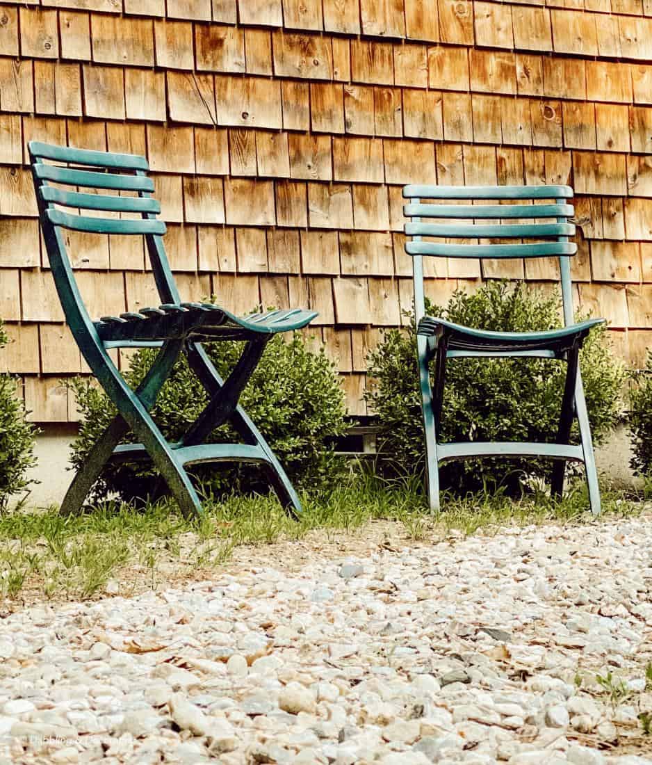 A couple of lawn chairs sitting on top of a wooden bench